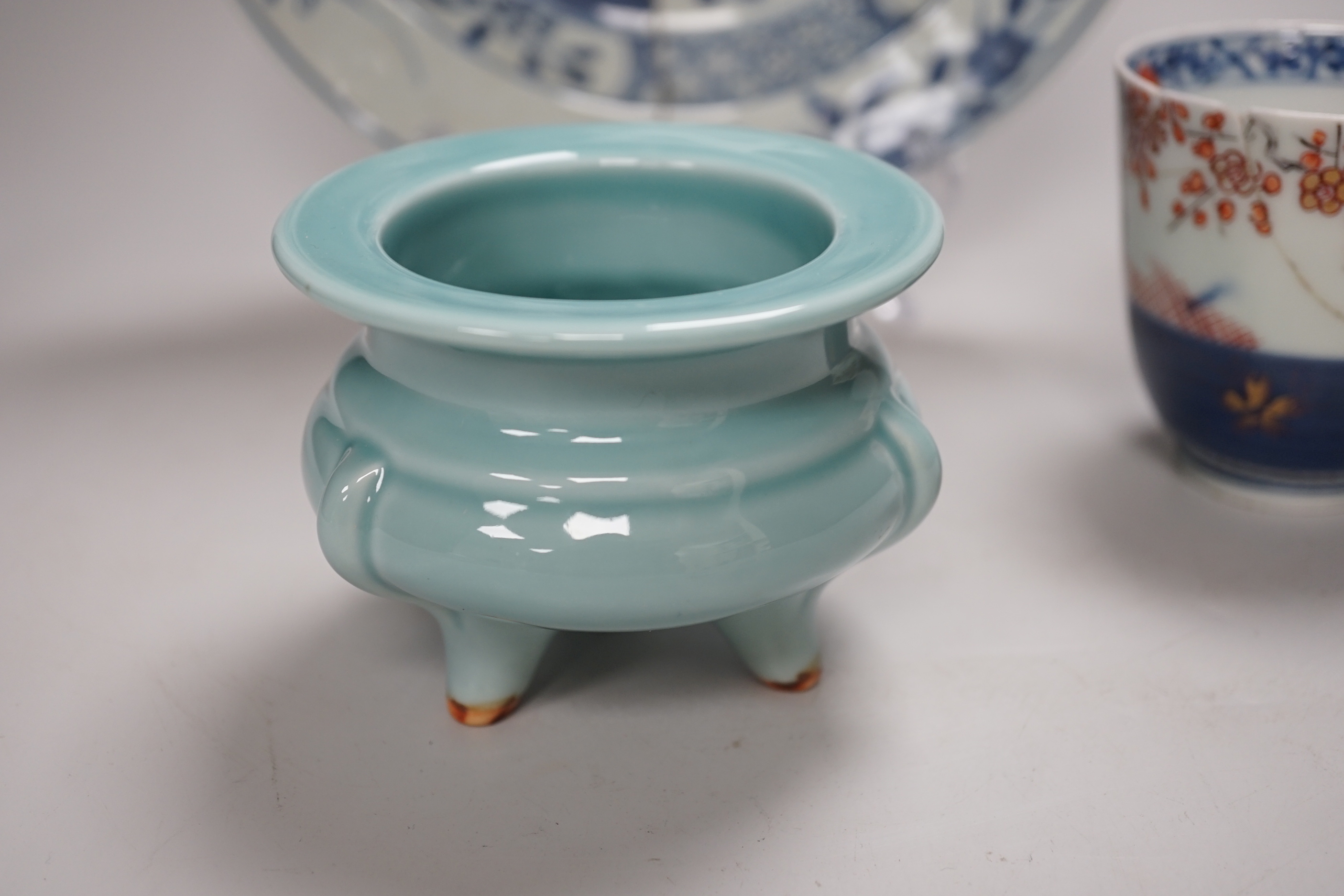 An 18th century Chinese export blue and white dish, celadon glazed tripod censer (20th century) and a Japanese Arita teacup